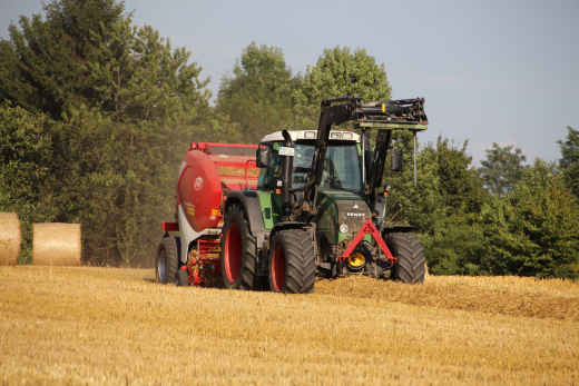 Traktor mit Rundballenpresse